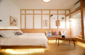 a bedroom with a large bed and a table at Qixin Homestay in Changsha