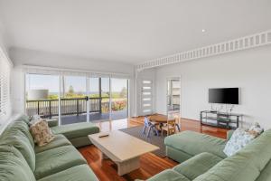 een woonkamer met een bank en een tafel bij Oceanfront Escape Kilcunda in Kilcunda