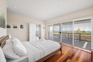 een slaapkamer met een groot bed en een balkon bij Oceanfront Escape Kilcunda in Kilcunda