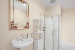 een witte badkamer met een wastafel en een douche bij Oceanfront Escape Kilcunda in Kilcunda +13 foto's