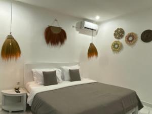una camera con letto e alcune decorazioni sul muro di Yuli Homestay a Uluwatu
