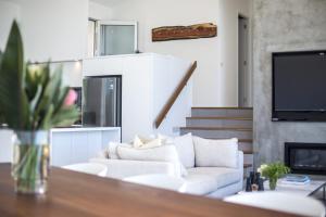 un salon avec un canapé blanc et une cheminée dans l'établissement Bawley Point Beach Front - oceanfront luxury home, à Bawley Point