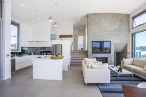 une cuisine et un salon avec un canapé et une table dans l'établissement Bawley Point Beach Front - oceanfront luxury home, à Bawley Point