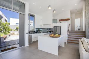 une cuisine avec des comptoirs blancs et un plan de travail dans l'établissement Bawley Point Beach Front - oceanfront luxury home, à Bawley Point