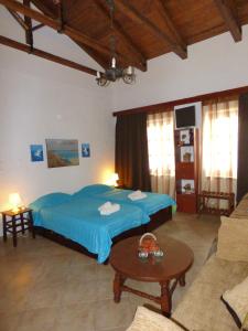 a bedroom with a blue bed and a table at Villa Belmar Self-Catered Apartments in Eretria