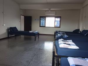una stanza con due letti e una finestra di Doctor Thanut Hostel a Ubon Ratchathani Altre 29 foto