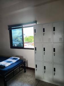 una stanza con armadietti bianchi e una finestra di Doctor Thanut Hostel a Ubon Ratchathani