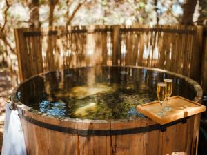 a hot tub with two glasses of wine at Pao Pao Lodge Algarrobo in Algarrobo