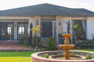 a house with a fountain in front of it at StayVista at Treeansh with Pool, Lawn in Mohali +33 photos