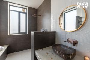 a bathroom with a large sink and a mirror at StayVista at Treeansh with Pool, Lawn in Mohali