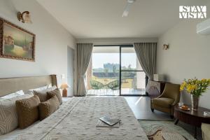 a hotel room with a bed and a living room at StayVista at Treeansh with Pool, Lawn in Mohali