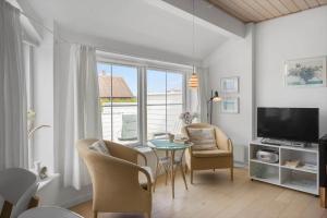 a living room with a table and chairs and a television at 323-Harboore-Skalvej-4-a in Harboør