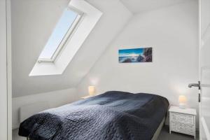 a white bedroom with a bed and a window at 323-Harboore-Skalvej-4-a in Harboør