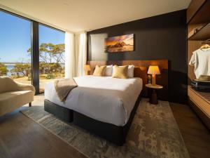 a bedroom with a large bed and a large window at Mercure Kangaroo Island Lodge in American River +129 photos