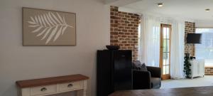 een woonkamer met een bank en een schilderij aan de muur bij River Dawn in Shoalhaven Heads +5 foto's