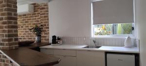 een witte keuken met een wastafel en een raam bij River Dawn in Shoalhaven Heads +5 foto's