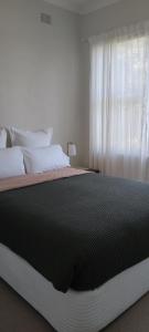 een groot bed in een slaapkamer met een raam bij River Dawn in Shoalhaven Heads