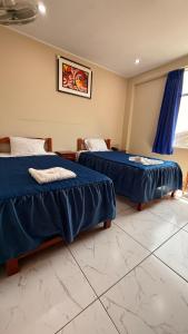 2 Betten in einem Zimmer mit blauer Bettwäsche in der Unterkunft Ikasur Hotel in Ica + 5 Fotos