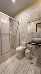 ein Badezimmer mit Toilette, Dusche und Waschbecken in der Unterkunft Ikasur Hotel in Ica