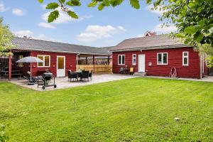 een rood huis met een patio en een tuin bij 727-Thyboron-Magevej-10 in Thyborøn