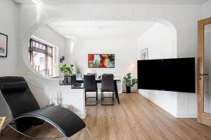een woonkamer met een tv en een tafel met stoelen bij 719-Thyboron-Fanovej-3 in Thyborøn