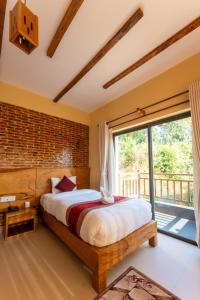 ein Schlafzimmer mit einem Bett und einem großen Fenster in der Unterkunft Pinnacle Lodge,Lakeside Pokhara in Kāskī