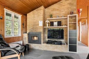 een woonkamer met een bakstenen muur en een open haard bij 0018-Romo-Trinnesvej-16 in Bolilmark