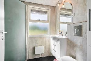 een badkamer met een wastafel en een toilet en een raam bij 0018-Romo-Trinnesvej-16 in Bolilmark +13 foto's