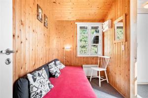 een kamer met een rode bank in een houten muur bij 0018-Romo-Trinnesvej-16 in Bolilmark