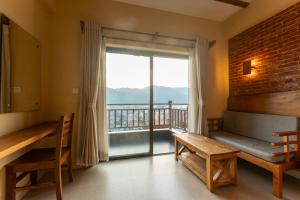 ein Wohnzimmer mit Couch und großem Fenster in der Unterkunft Pinnacle Lodge,Lakeside Pokhara in Kāskī