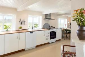 a kitchen with white cabinets and a dining room at 0002-Romo-Juvrevej-89 in Høm
