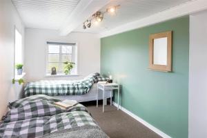two beds in a room with green walls at 0002-Romo-Juvrevej-89 in Høm