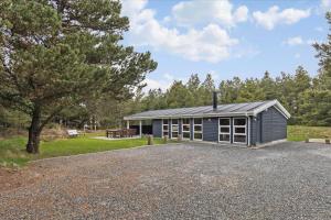 een klein blauw huis met een grindoprit bij 0001-Romo-Blabaervej-23 in Bolilmark