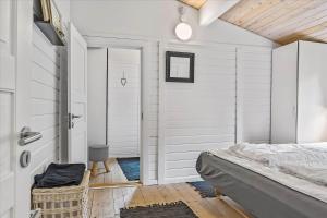 een slaapkamer met witte muren en een bed en een deur bij 0001-Romo-Blabaervej-23 in Bolilmark