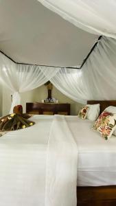 a bedroom with a white bed with a canopy at Balangan Sea View Bungalow in Jimbaran