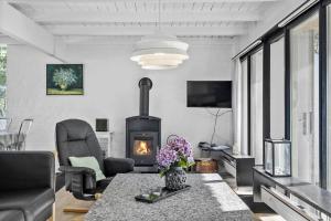 a living room with a fireplace and a table at 0005-Romo-Moritzvej-5 in Høm