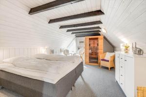 a bedroom with a large bed in a white room at 0005-Romo-Moritzvej-5 in Høm