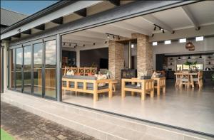 un'ampia estensione in vetro di una casa con patio di Highland gate Golf estate Mountain view 780 a Dullstroom