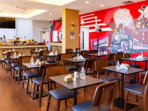 a dining room with tables and chairs in a restaurant at ibis Ourinhos in Ourinhos