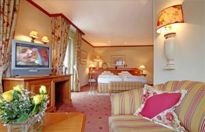 バーデンヴァイラーにあるホテル ベーリンガーズ トラウベのテレビとベッド2台が備わるホテルルームです。