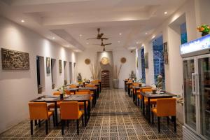 een restaurant met tafels en stoelen in een kamer bij Boutique Indochine d'Angkor in Siem Reap