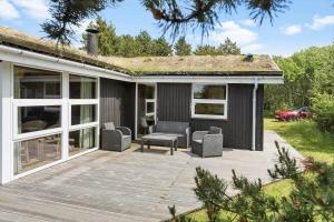 a deck with chairs and a couch on a house at 0021-Romo-Ringvejen-74 in Høm
