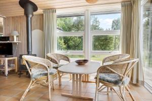 a dining room with a table and chairs and windows at 0021-Romo-Ringvejen-74 in Høm