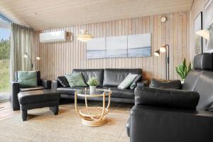 a living room with a black couch and a table at 0021-Romo-Ringvejen-74 in Høm