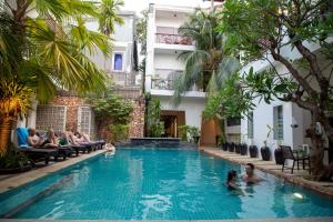 een groep mensen in het zwembad van een hotel bij Boutique Indochine d'Angkor in Siem Reap