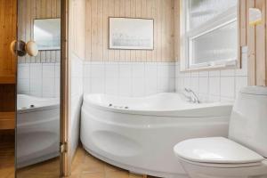 a bathroom with a tub and a toilet and a sink at 0021-Romo-Ringvejen-74 in Høm +23 photos