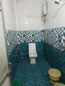 een badkamer met een toilet en blauwe en witte tegels bij Kashi darshan in Varanasi
