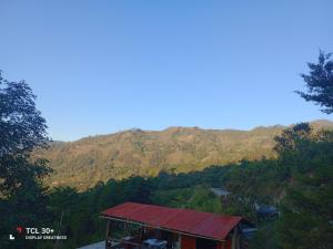 una piccola casa con il tetto rosso in montagna di Ecuturisticos Barbacoa casa de la luna a Cáqueza Altre 4 foto