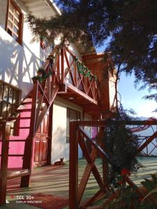 una casa con una porta rosa e un cancello di legno di Ecuturisticos Barbacoa casa de la luna a Cáqueza