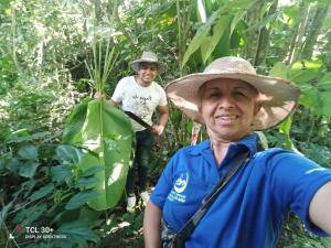 un uomo che indossa un cappello di paglia in piedi nella giungla di Ecuturisticos Barbacoa casa de la luna a Cáqueza